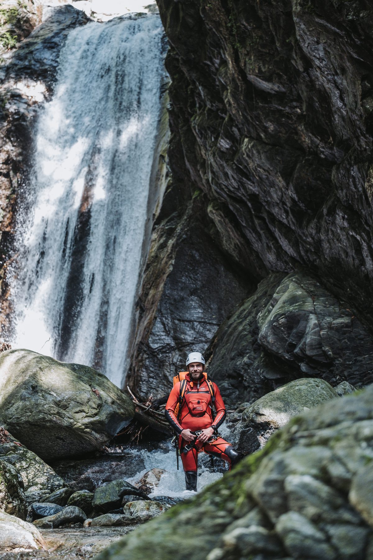 Guide auf Fels vor riesigem Wasserfall